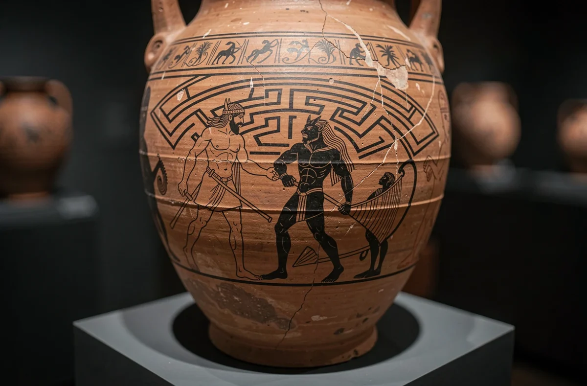Détail d'une amphore grecque antique peinte représentant Thésée affrontant le Minotaure dans un labyrinthe stylisé